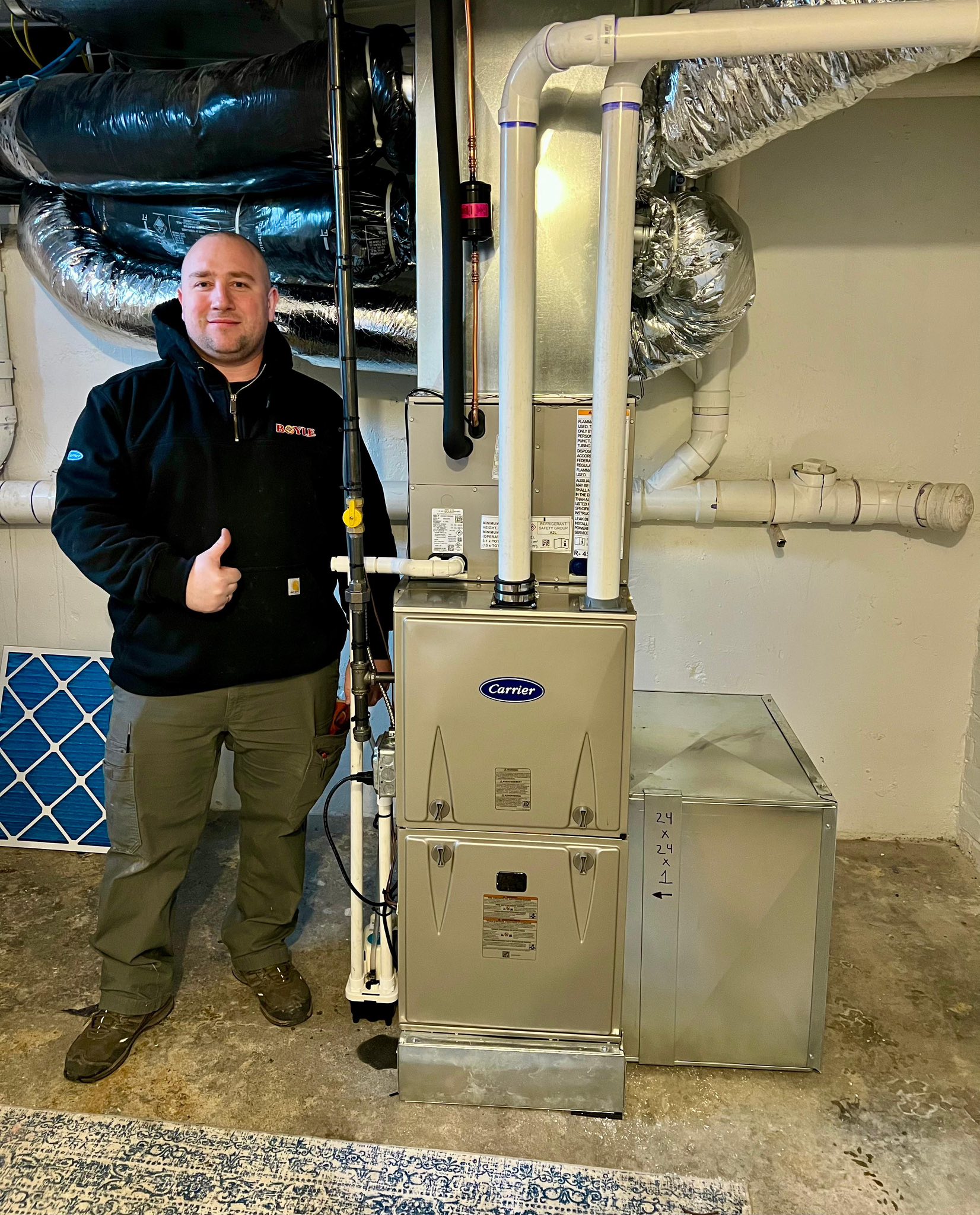 An HVAC technician standing beside an HVAC System.