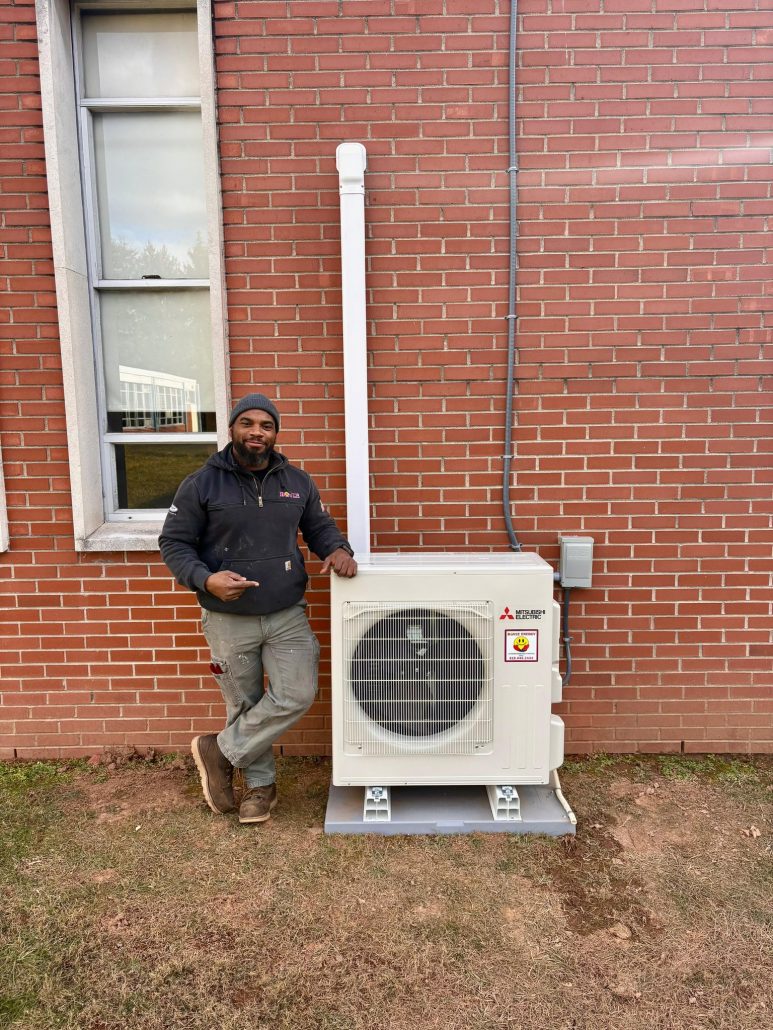 Boyle Energy Technician standing with an AC Heat Pump