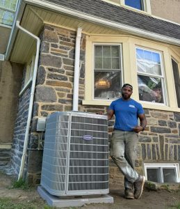 Boyle technician standing in front of a hone with an AC unit